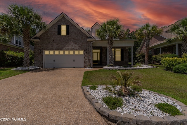 view of front of property with a garage and a yard