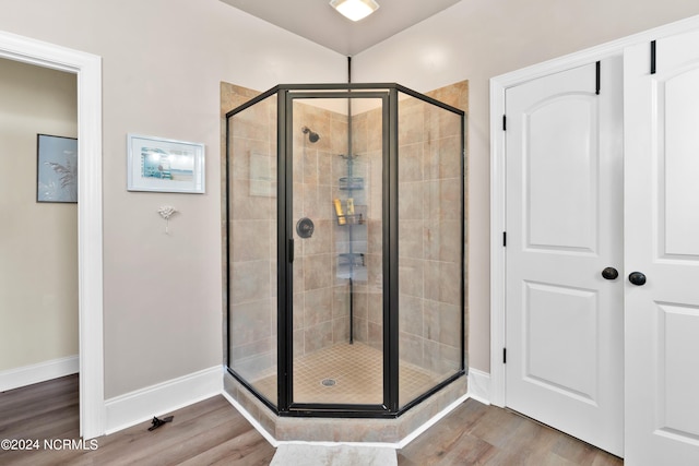 bathroom featuring hardwood / wood-style flooring and an enclosed shower