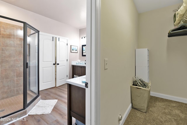 bathroom featuring hardwood / wood-style floors, vanity, and an enclosed shower