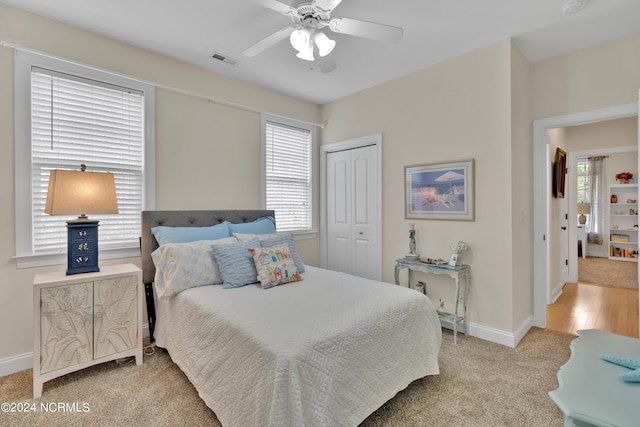 bedroom featuring a closet, ceiling fan, and light colored carpet