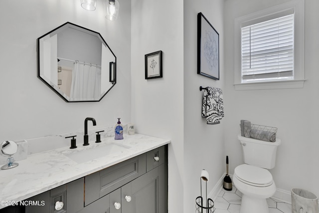 bathroom with tile patterned flooring, vanity, and toilet