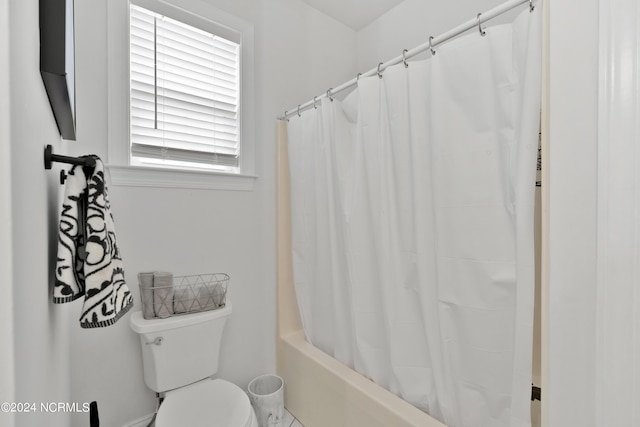 bathroom featuring shower / bath combo and toilet