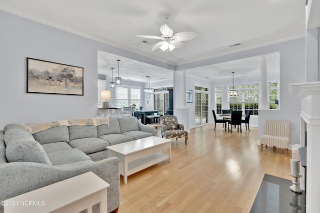 living room featuring ceiling fan, ornamental molding, and light wood-type flooring