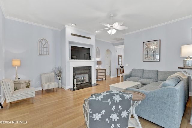 living room with ceiling fan, wood-type flooring, and ornamental molding