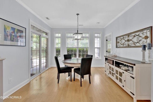 dining room with light hardwood / wood-style floors, an inviting chandelier, and crown molding