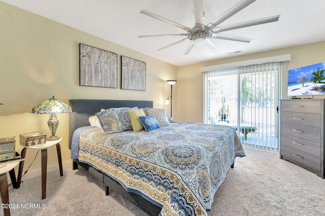 carpeted bedroom with ceiling fan, access to exterior, and a textured ceiling