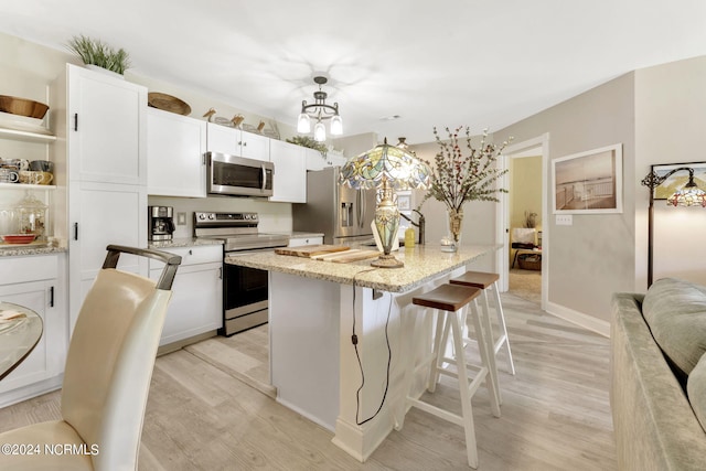 kitchen featuring white cabinets, appliances with stainless steel finishes, and light wood-type flooring