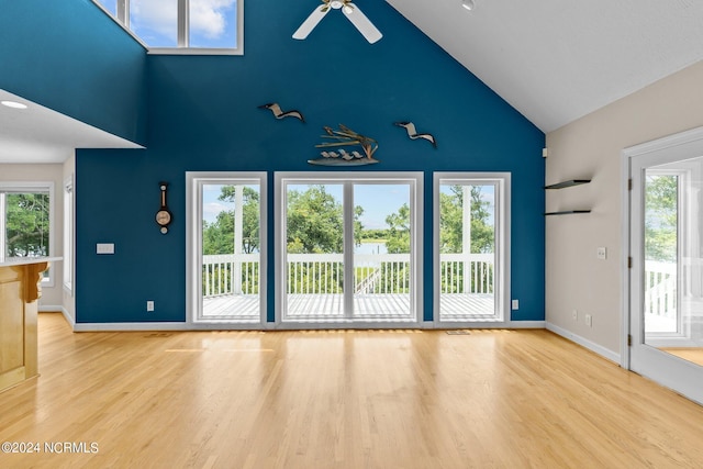 unfurnished living room featuring ceiling fan, light wood-type flooring, and a wealth of natural light