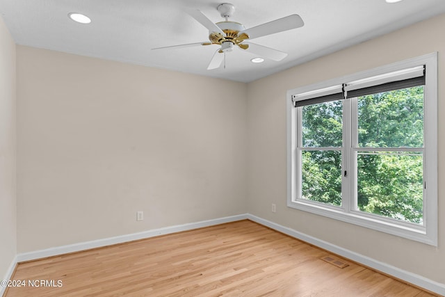 empty room with ceiling fan and light hardwood / wood-style flooring