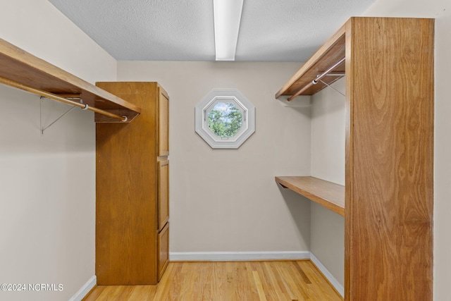 walk in closet with light wood-type flooring