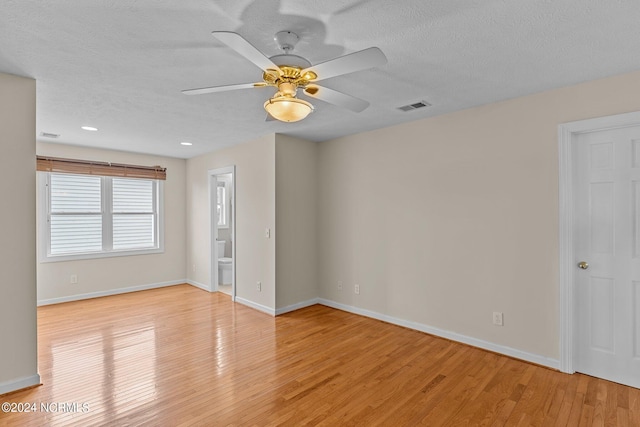 unfurnished room with ceiling fan, a textured ceiling, and light wood-type flooring