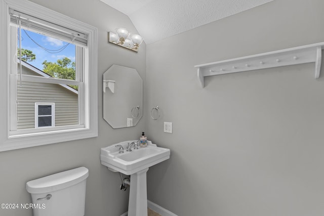 bathroom featuring a textured ceiling, toilet, and lofted ceiling