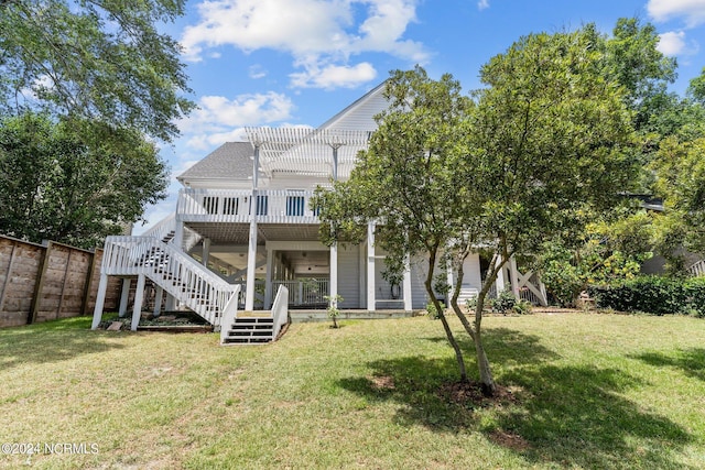 back of house with a lawn, a pergola, and a wooden deck