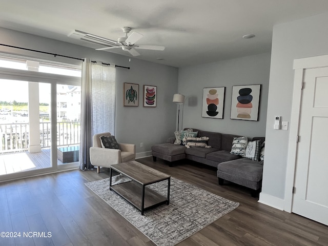 living room with ceiling fan and dark wood-type flooring