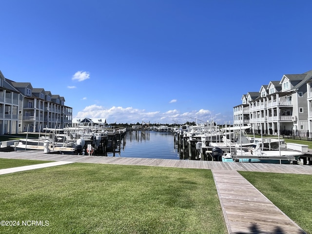 view of dock featuring a water view and a yard