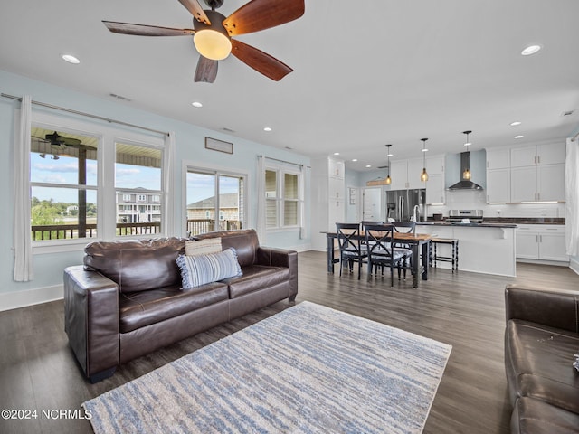 living room with ceiling fan and dark wood-type flooring