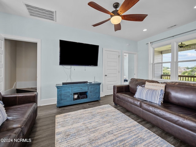 living room with ceiling fan and dark wood-type flooring