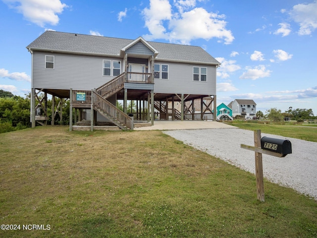 rear view of house featuring a carport and a lawn