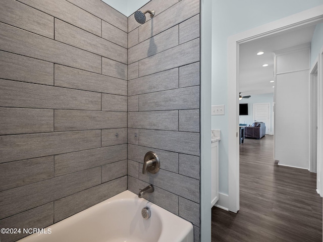 bathroom with tiled shower / bath combo, ceiling fan, and wood-type flooring