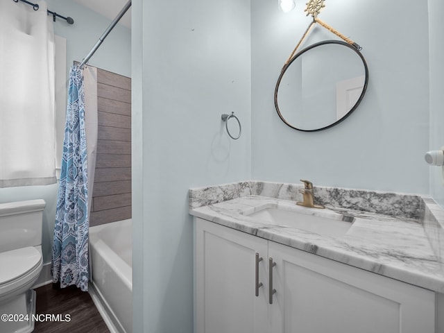 full bathroom with hardwood / wood-style floors, vanity, shower / bath combination with curtain, and toilet