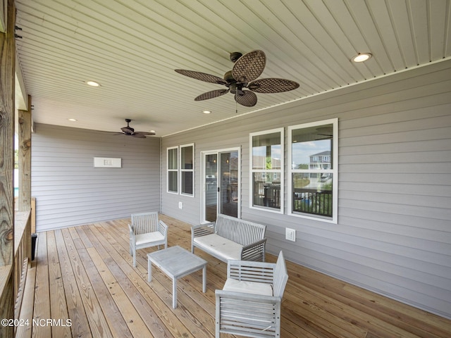 wooden deck with outdoor lounge area and ceiling fan