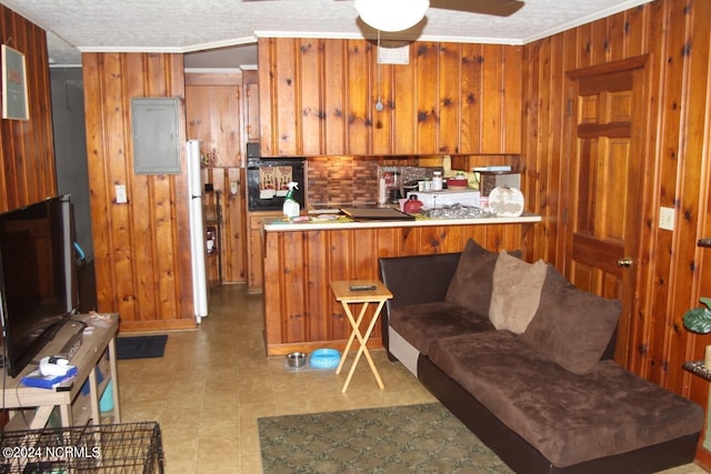 kitchen featuring wood walls, ceiling fan, ornamental molding, white fridge, and kitchen peninsula