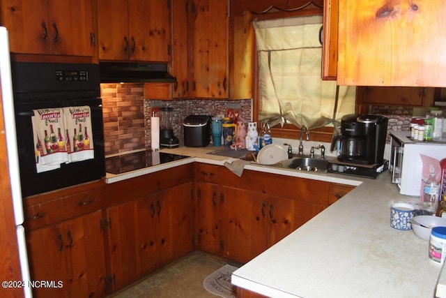 kitchen featuring sink, tasteful backsplash, and black appliances