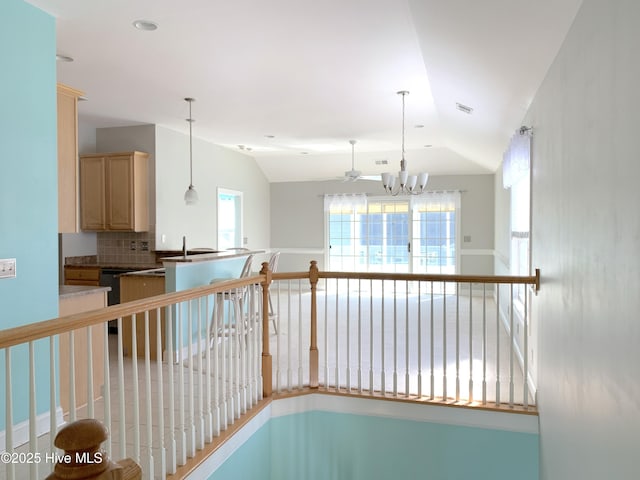 hallway featuring an inviting chandelier and lofted ceiling