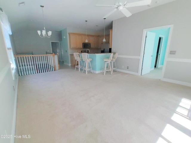 kitchen with stainless steel refrigerator, light brown cabinets, light colored carpet, and pendant lighting