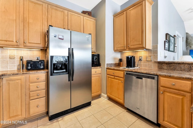 kitchen with tasteful backsplash, light tile patterned floors, and stainless steel appliances