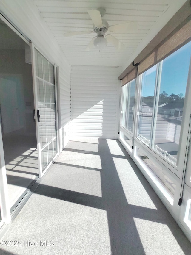 unfurnished sunroom with ceiling fan