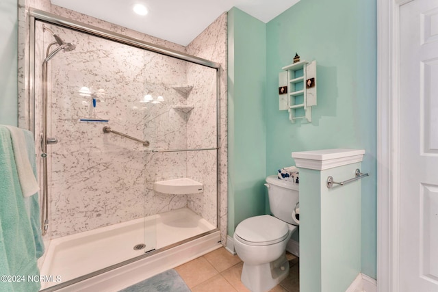 bathroom with toilet, tile patterned floors, and a shower with shower door