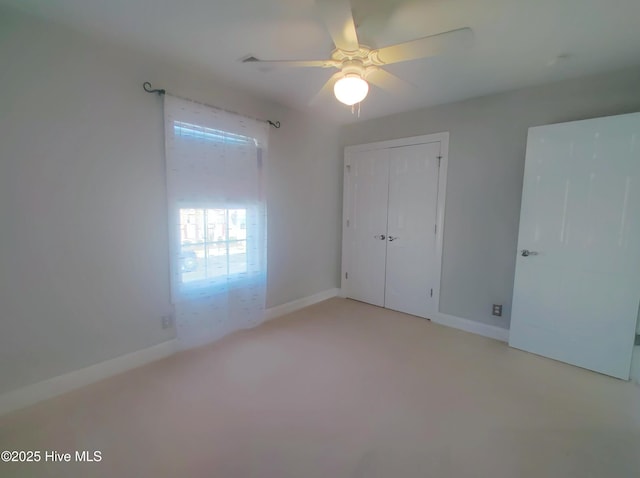 unfurnished bedroom featuring ceiling fan, light colored carpet, and a closet