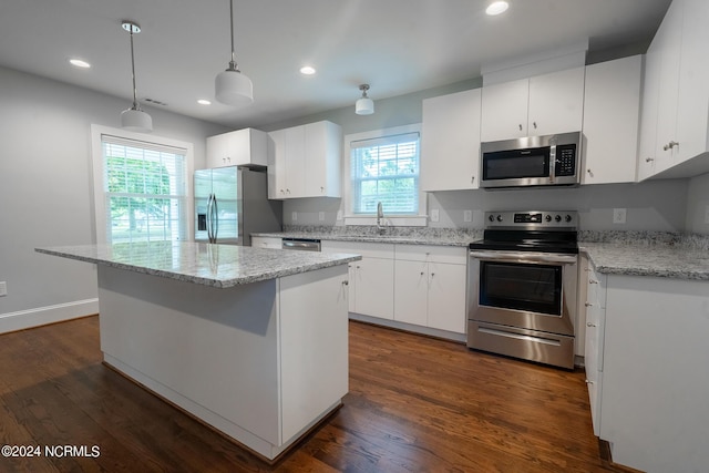 kitchen with appliances with stainless steel finishes, a kitchen island, and white cabinets