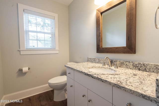 bathroom featuring wood-type flooring, vanity, and toilet