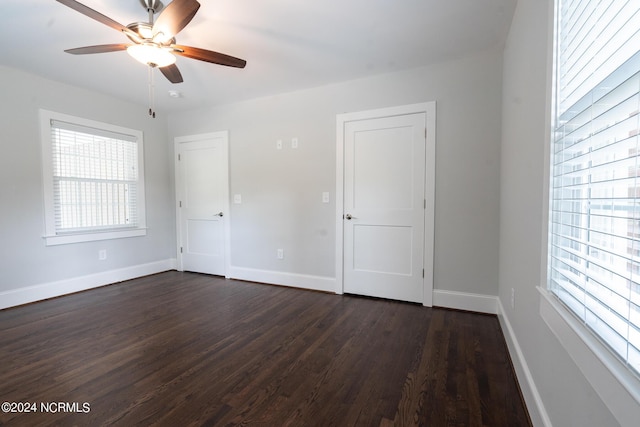 spare room with dark wood-type flooring, ceiling fan, and plenty of natural light