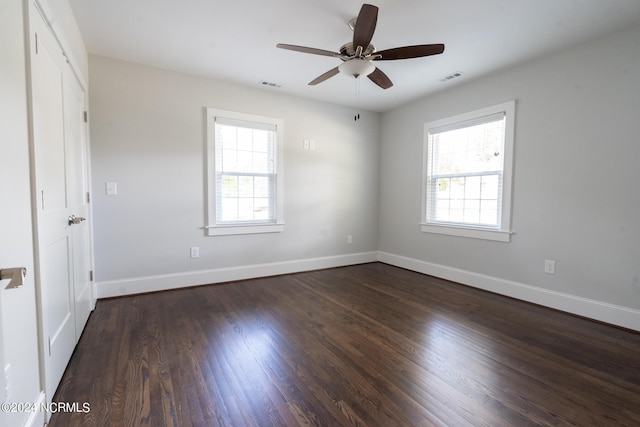 unfurnished room featuring ceiling fan, dark hardwood / wood-style flooring, and a wealth of natural light