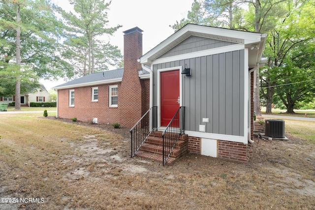 view of front of home featuring central AC unit and a front lawn