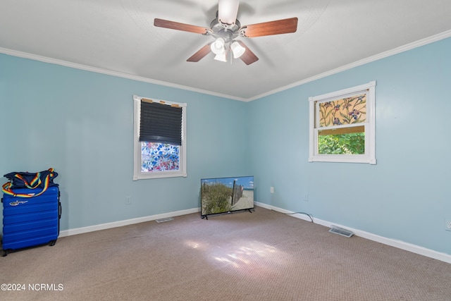 carpeted empty room featuring ornamental molding and ceiling fan