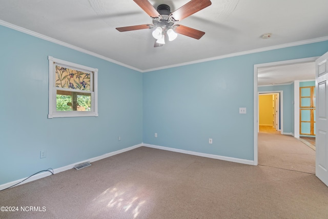 empty room with crown molding, light colored carpet, and ceiling fan