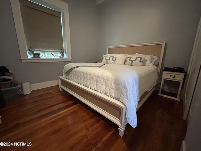 bedroom with dark hardwood / wood-style flooring