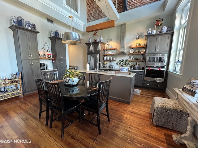 dining room with a high ceiling, dark hardwood / wood-style floors, and sink