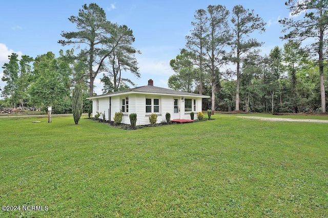 exterior space with a yard and a chimney