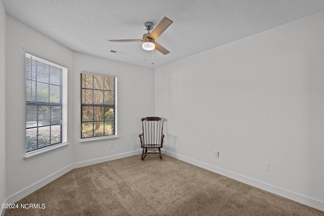 unfurnished room featuring ceiling fan, carpet floors, and a textured ceiling