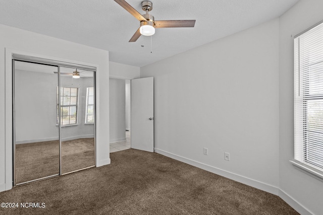 unfurnished bedroom featuring ceiling fan, a closet, and carpet floors