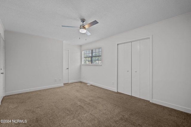 unfurnished bedroom with ceiling fan, carpet floors, a textured ceiling, and a closet