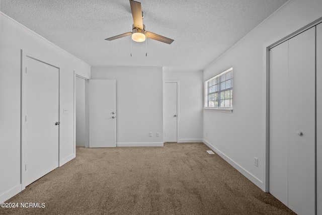 unfurnished bedroom featuring a textured ceiling, ceiling fan, and light carpet