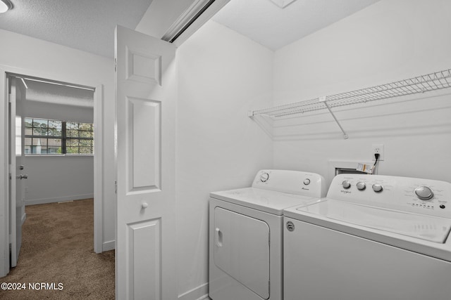 clothes washing area featuring a textured ceiling, separate washer and dryer, and dark carpet