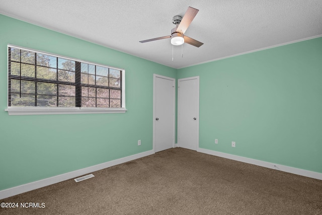 spare room featuring carpet, ceiling fan, and a textured ceiling