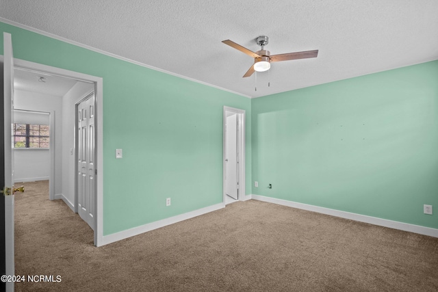 unfurnished room with ceiling fan, light colored carpet, and a textured ceiling